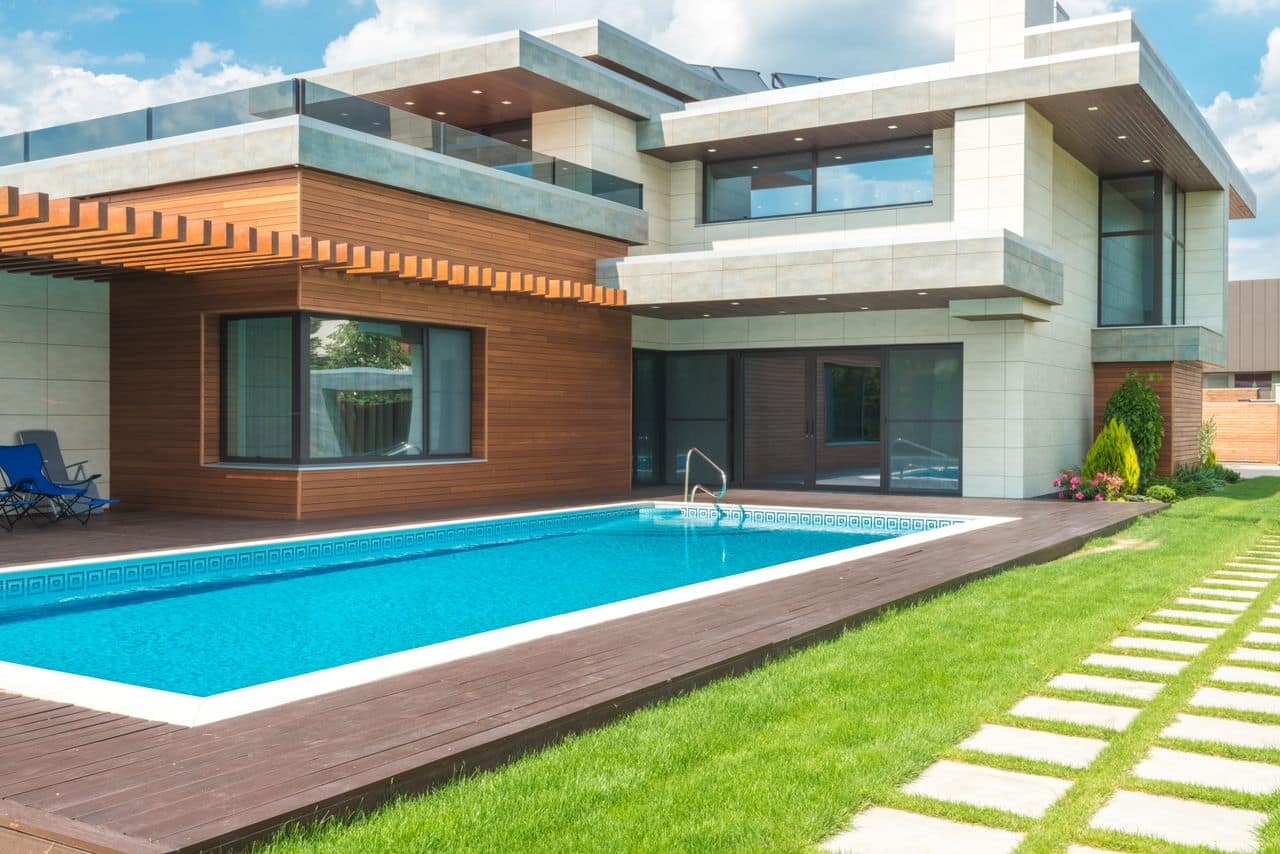 Tropical luxury home with pool, palms and timber screening at golden hour