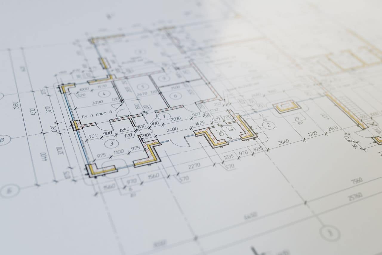 Architectural plans and timber model on a design studio table